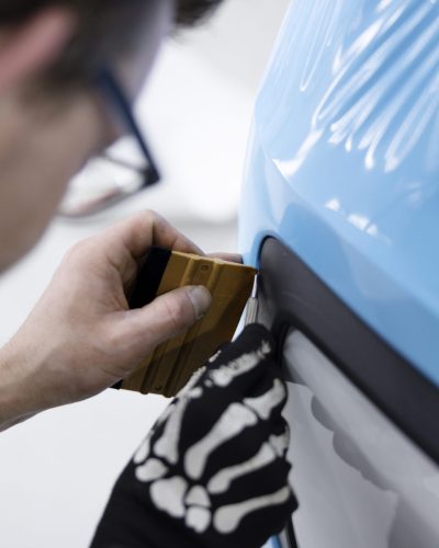 cerrar-hombre-envolviendo-coche-cubierta-azul